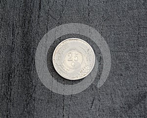 25 (twenty five) cent Netherlands Antillean guilder coin on black background