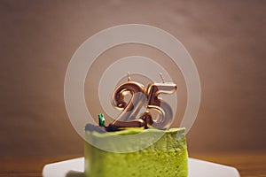 Twenty five years anniversary. Birthday chocolate cake with white burning candles in the form of number Twenty five