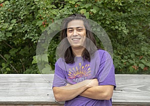 Twenty-three year old Amerasian male posing on wooden bridge in Washington Park Arboretum, Seattle, Washington