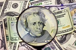 Twenty usa dollar bill inspected under a magnifying glass. Financial concept, money background.