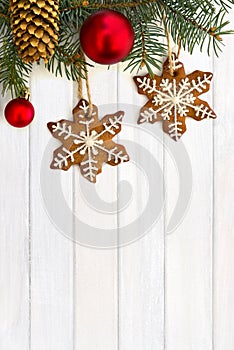 Twigs of christmas tree with Christmas balls, christmas gingerbread and cones spruce on background of white painted wooden planks