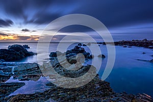 Twilight begins yielding to daylight at rocky coastline