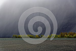 View to storm eerie scenery at lake, dramatic sky photo