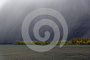 View to storm eerie scenery at lake, dramatic sky