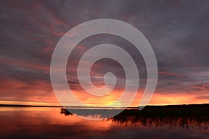 Twilight sky in the bright glow of sunset over the calm water of the lake