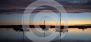 Twilight sunset over Morro Bay Harbor boats on the central California coast in California USA