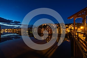 Twilight view of colorful wooden buildings on stilts along the Nidelva River, Trondheim, Norway