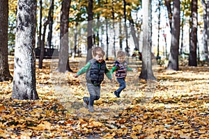 Twin brothers in autumn ouside in the park