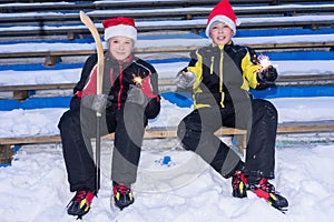 Twin brothers holding bengal sticks on the ice rink