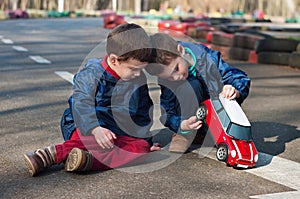 Twin brothers play with a toy car