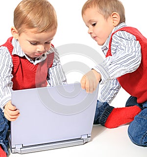 Twin brothers playing woth laptop