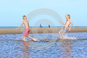 Twin brothers running on the beach
