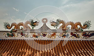 Twin Chinese dragons sculpture decorate on chinese-style temple roof