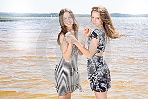 Twin cute beauty teenage girls playing on beach