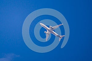 Twin-engine airplane flying in clear blue sky, passenger plane