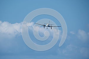 Twin-engine plane in the sky against the clouds.