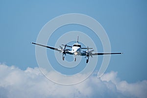 Twin-engine plane in the sky against the clouds.