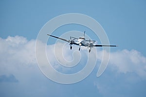 Twin-engine plane in the sky against the clouds.