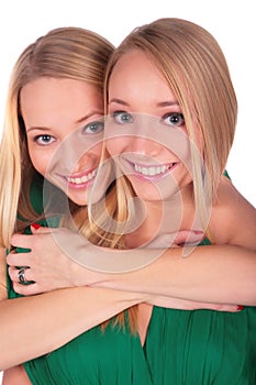 Twin girls embrace from behind