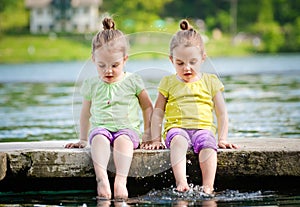 Twin girls exercising on a lake shore