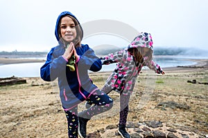 Twin girls standing on remains of ancient roman water well