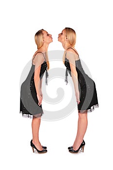 Twin girls stands face-to-face kissing