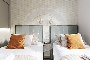 Twin headboards of youthful beds upholstered in gold