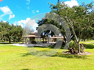 Twin Lakes Park in Sarasota Florida under a bright sunny blue sky with white fluffy clouds a lake and trees