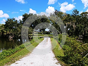 Twin Lakes Park in Sarasota Florida under a bright sunny blue sky with white fluffy clouds a lake and trees