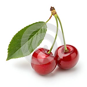 Twin red cherries with a green leaf isolated on white background