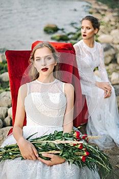 Twin sisters in wedding dress on the seashore