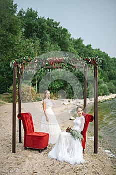 Twin sisters in wedding dress on the seashore