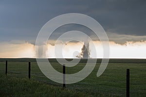 Twin tornadoes churn dirt on the high plains of Colorado.