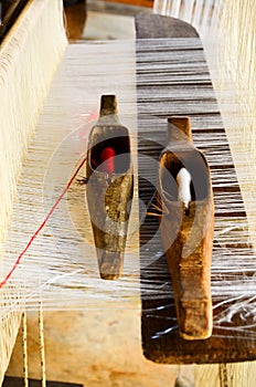 Twin Weaving shuttles on yarn and wooden loom