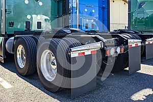 Twin wheels axles of big rigs semi trucks tractors with large tread pattern on tires for better grip