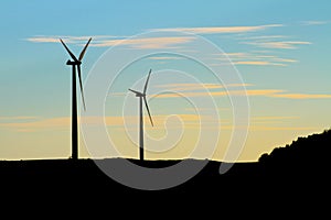 Twin wind turbine silhouettes at dawn