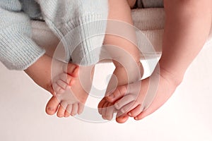 Twins are babies. A close-up photo of the legs of newborn twins. Feet and fingers of a newborn.