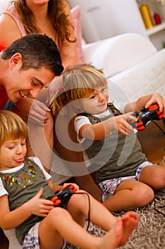 Twins daughters playing on console at home