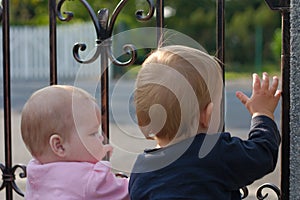 Twins at gate waving hand