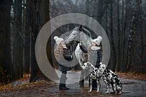 Twins girls portrait with Appaloosa horse and Dalmatian dogs