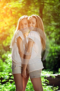 Twins. A group of young beautiful girls. Two women face close-up. Trendy stylish sisters