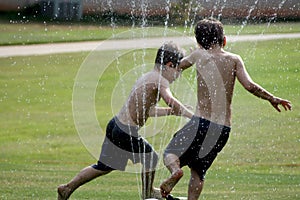 Twins running in Sprinkler