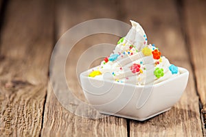 Twirled vanilla ice cream with colorful candy photo