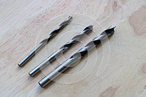 Twist drill bits on wooden background