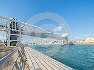 Twisted Bridge. Structure of architecture with lake or river, Dubai Downtown skyline, United Arab Emirates or UAE. Financial