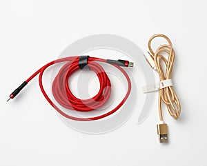 Twisted cable for charging mobile devices in a red and golden textile wrapper