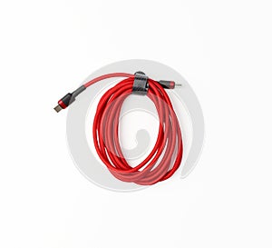 Twisted cable for charging mobile devices in a red textile wrapper