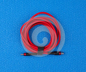 Twisted cable for charging mobile devices in a red textile wrapper