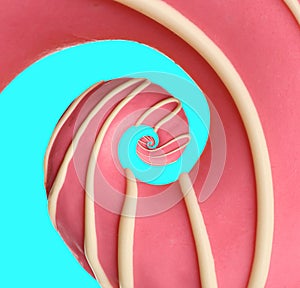 Twisted donut with strawberry icing and topping on cyan background, spiral effect