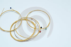 Twisted new guitar strings on white background. New acoustic guitar strings